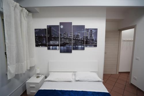 TirioloAYN Apartment的卧室配有一张壁挂着四幅画作的床