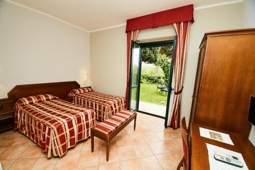 蒙塔尔托迪卡斯特罗HOTEL VULCI的一间卧室设有两张床和滑动玻璃门