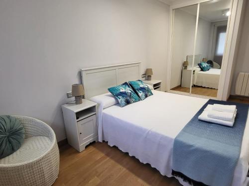 博伊罗Playa Jardin Boiro的一间卧室配有一张带镜子和椅子的床
