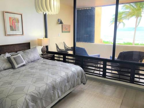 乌马考Beachfront Getaway for two!的一间卧室设有一张床和一个大窗户