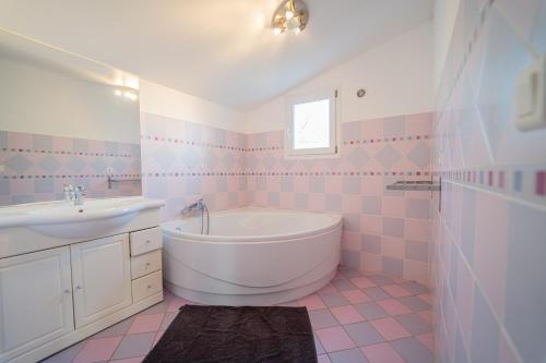 BastelicacciaL'ALIVETTE的粉红色和白色的浴室设有浴缸和水槽