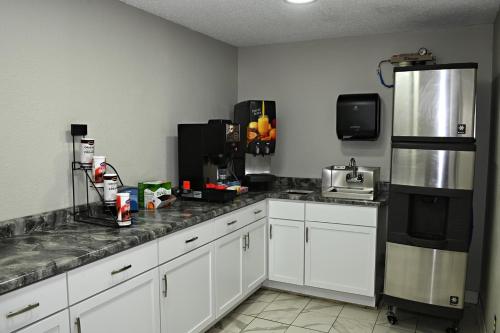 HibbingHibbing Inn & Suites的厨房配有白色橱柜和黑色冰箱。
