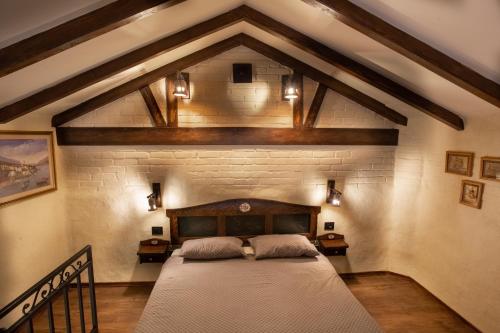 斯雷姆斯卡米特罗维察Apartmani Sirmium的卧室设有一张砖墙内的大床