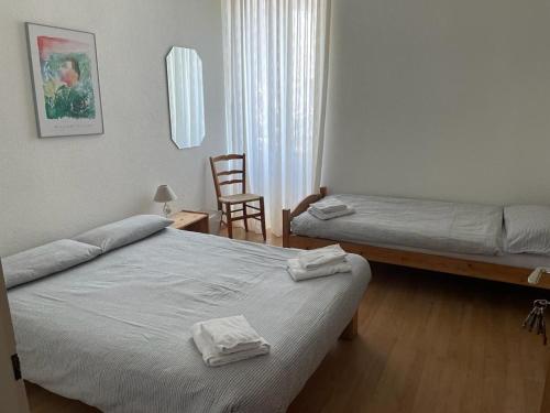 加维科利亚诺Hotel Bellavista Cavigliano的酒店客房,配有两张床和椅子