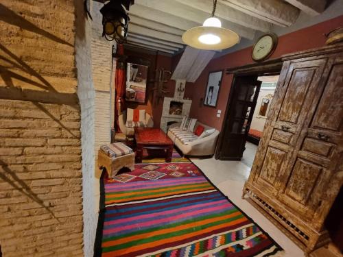 托泽尔Dar El Sultan Tozeur的一间客厅,地板上铺着色彩缤纷的地毯