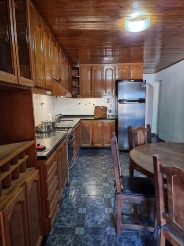 圣拉斐尔Casa Nina San Rafael的厨房配有木制橱柜、桌子和冰箱。