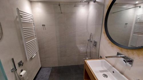 卡斯特尔罗托Valentino Apartment的带淋浴、盥洗盆和镜子的浴室