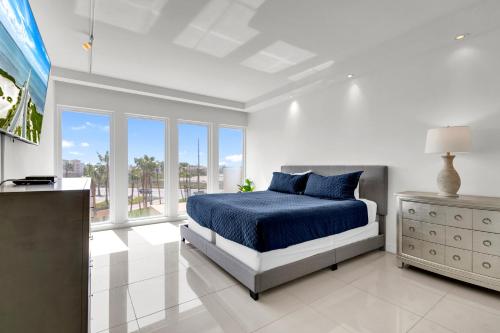 南帕诸岛Perfect condo, room for everyone! Beachfront resort的白色卧室设有蓝色的床和窗户
