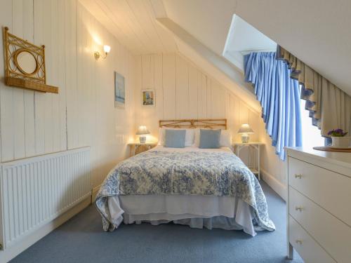 以撒港Edgehill的一间卧室配有一张带蓝色和白色床单的床。