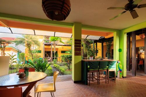 卡维塔Hotel Boutique La Casa de las Flores的餐厅拥有绿色的墙壁和桌椅