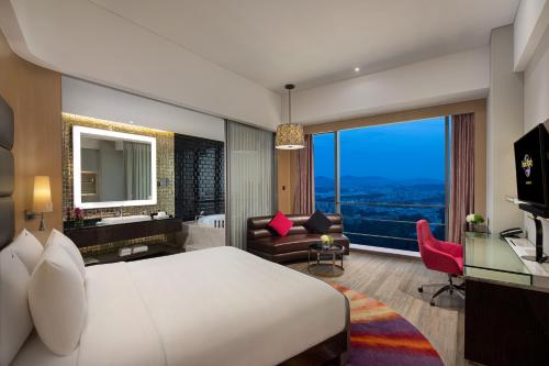 深圳深圳硬石酒店的酒店客房设有一张大床和一张书桌。