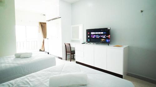 Ban Tha MakhamPT Grand Hotel的一间卧室配有两张床和一台平面电视