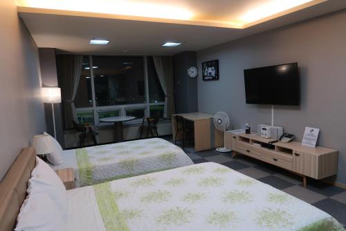 仁川市普莱姆宾馆的酒店客房设有两张床和一台平面电视。