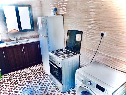 亚喀巴Galaxy Apartments的厨房配有炉灶和冰箱。