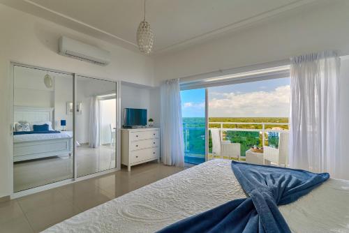 璜多里奥Sunset View 2BR Apartamento Juan Dolio Las Velas的一间卧室配有一张床,享有海景