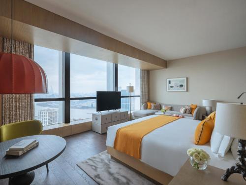 上海上海西岸美高梅酒店的一间卧室设有一张大床和一个大窗户