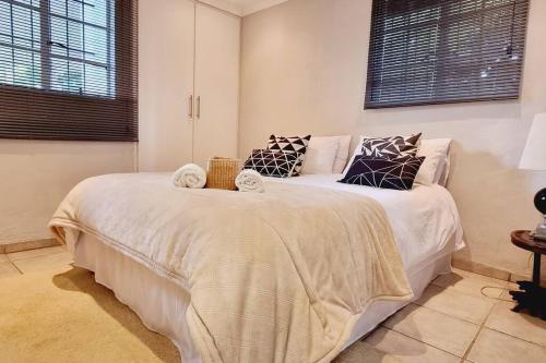 Bothaʼs HillHerbie's Hideout: 1 Bed Cottage W/ View and Pool的卧室配有一张带白色床单和枕头的大床。