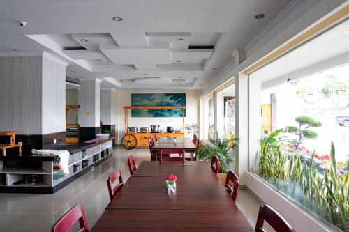 巴拉巴特Khas Parapat的客房设有桌椅和大窗户。