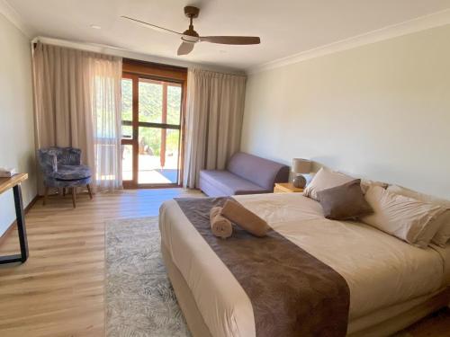Arkaroola阿卡露拉荒野保护区酒店的一间卧室配有一张床、一张沙发和一把椅子