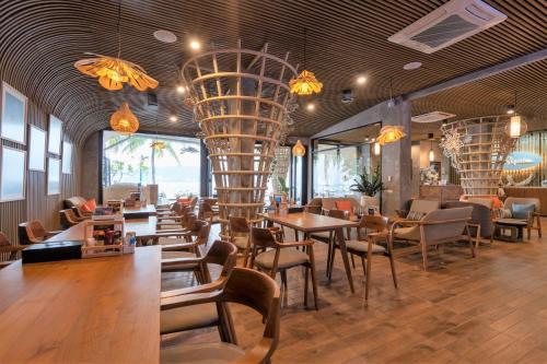 芭东海滩Patong Signature Boutique Hotel的一间带桌椅和吊灯的餐厅