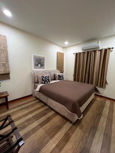Ban Chak PhaiNew Home Yบ้านเดี่ยวสร้างใหม่ ใกล้ทะเล ใจกลางเมืองระยอง的一间卧室配有一张大床和一张沙发