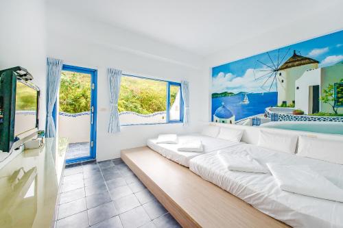 小琉球岛白灯楼旅宿的白色的客房设有一张大床和窗户。
