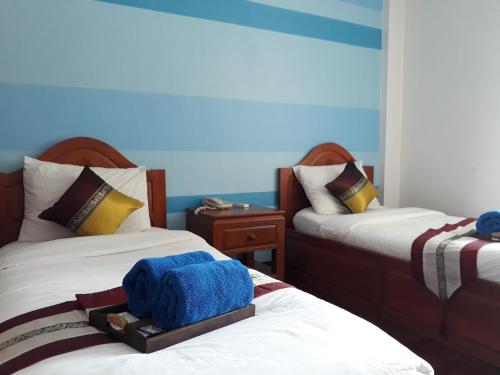 清迈维瑞雅别墅酒店的一间卧室配有两张带毛巾的床