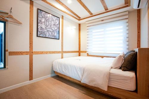 木浦市Geonmaek Stay的一间卧室设有一张床和一个窗口