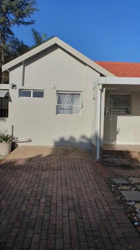 伊登维尔Refreshing Space in Eden Glen, Johannesburg, SA的砖车道的白色房子