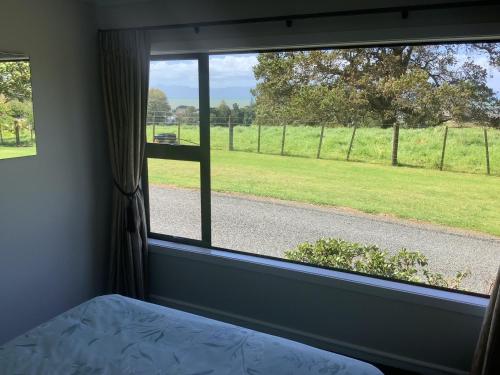 奥克兰Kaiaua Bayview Farm Apartment的一间卧室设有窗户,享有田野美景