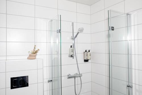 奥斯陆Bob W Sentralen的浴室铺有白色瓷砖,设有淋浴。