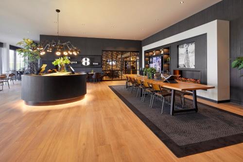 布雷达Gr8 Hotel Breda的大堂设有桌椅和酒吧。