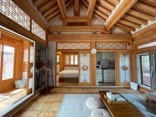 求礼郡Hanok Stay - JukRokJungSa的一间带木制天花板的客厅和一间卧室。