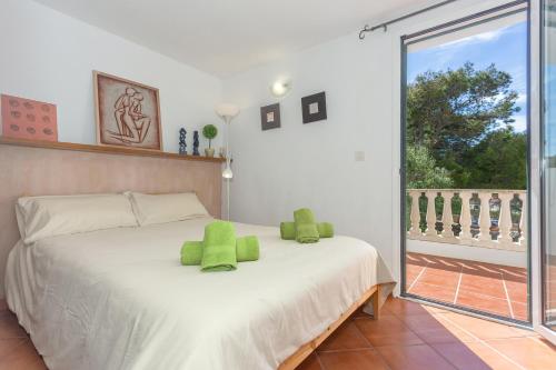 休达德亚Arbocers的一间卧室配有一张带绿色枕头的床。