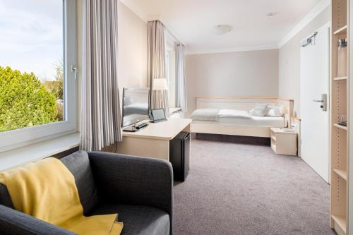比苏姆多恩AKZENT酒店的酒店客房配有床、沙发和电视。