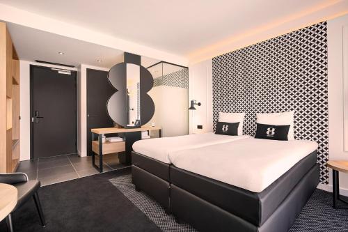 布雷达Gr8 Hotel Breda的配有一张床和一张书桌的酒店客房