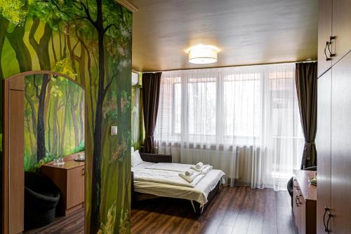 尼赖吉哈佐Ózoon Hotel的一间卧室配有床和树壁画