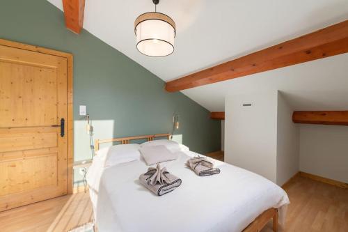 Ban-sur-Meurthe-ClefcyLe Cerf, chalet cocooning avec piscine et billard的卧室设有一张白色大床和天花板