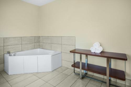 雪松城锡达城智选假日酒店的带浴缸和桌子的浴室