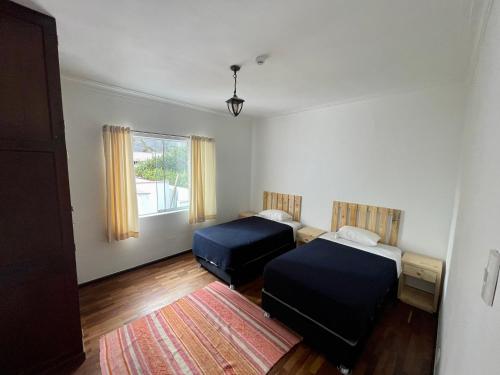 利马Casaroma Hostels的一间带两张床的卧室和地毯