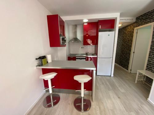 马德里Apartamento Cuzco的厨房配有红色橱柜和白色冰箱