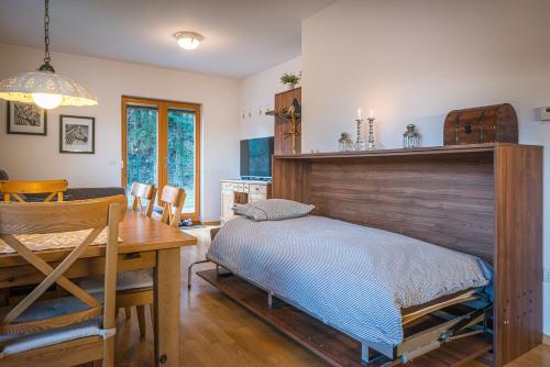 克拉尼斯卡戈拉Apartments Plan Kranjska Gora的一间卧室配有一张床和一个木制床头板