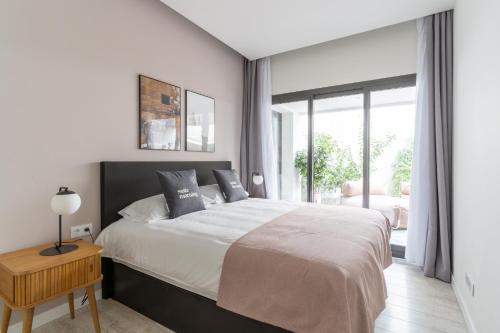 巴塞罗那limehome Barcelona Rector Triadó的白色的卧室设有一张大床和一个窗户