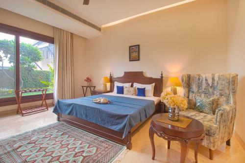 阿姆利则Ekant Villa with Pvt Pool at Amritsar by StayVista的一间卧室配有一张床、一把椅子和一张桌子