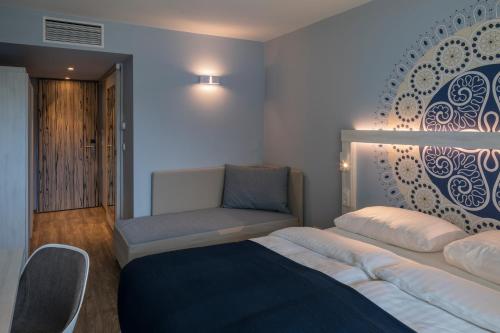 扎达尔法肯斯特尼俱乐部弗尼马申波瑞可酒店的一间卧室配有一张床、一张沙发和一把椅子