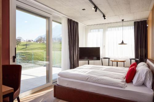 屈斯纳赫特Tailormade Hotel RIGIBLICK Küssnacht的一间卧室设有一张床和一个大窗户