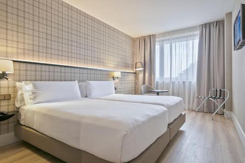 巴塞罗那阿克塔城市47就的一张大白色的床,位于酒店客房内