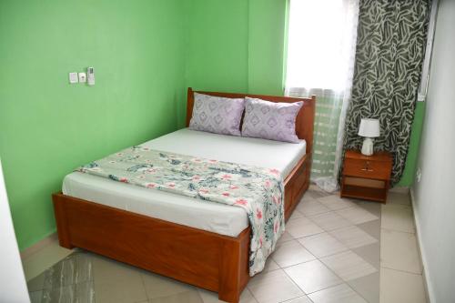 杜阿拉Spetiv Guesthouse的一张小床,位于一个绿色的墙壁内
