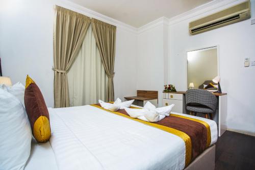 多哈别墅套房酒店的酒店客房带一张床、一张书桌和一面镜子