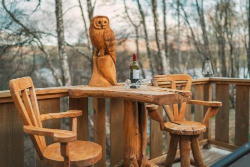 伊文格瑞Caledonian Cabin的一张木桌、一瓶葡萄酒和两把椅子